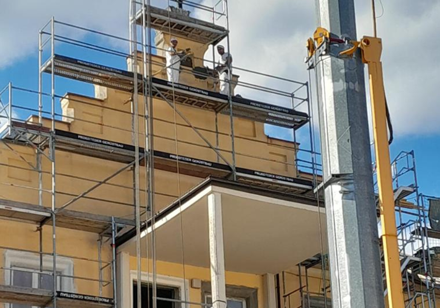 Arbeiten am Giebel – Handwerker auf Gerüst