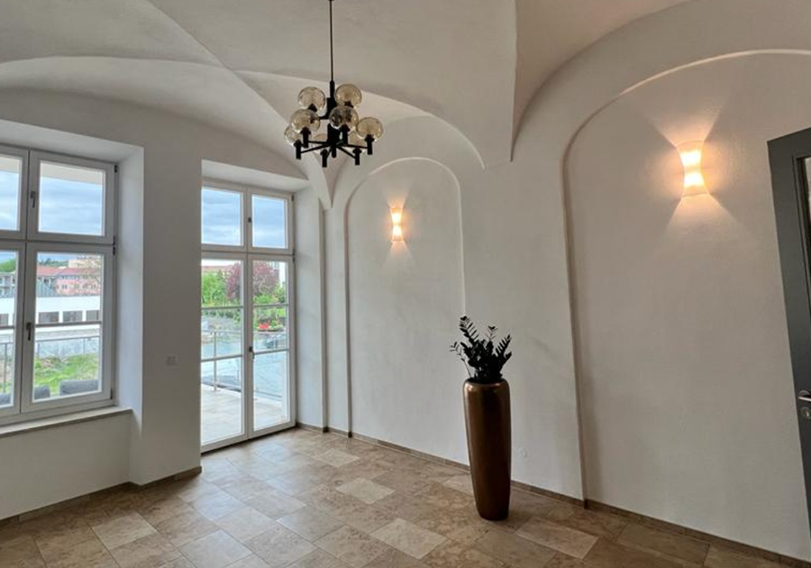 Gewölberaum mit Natursteinboden und Balkonzugang