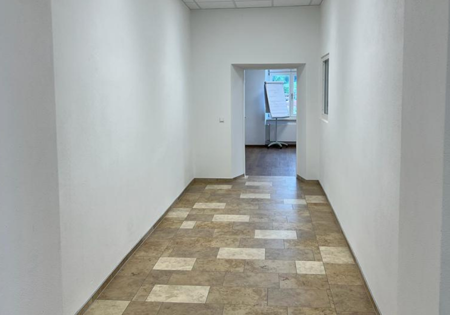 Sanierter Flur mit Rasterdecke und Natursteinboden